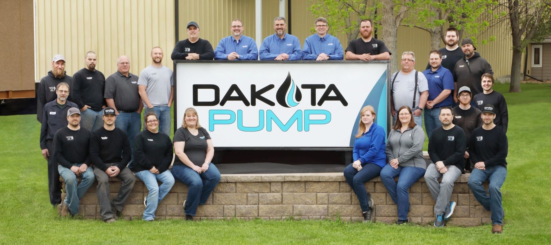 The Dakota Pump team gathered in front of the Dakota Pump sign at the Mitchell, SD facility